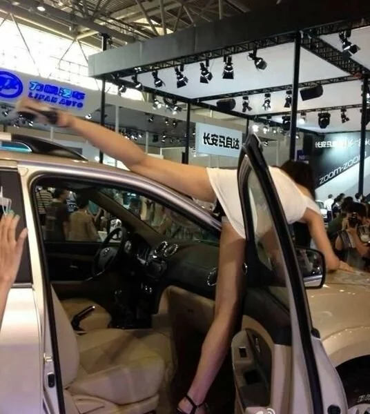 В китайском автосалоне девушка полностью отрабатывает свою зарплату (5 фото)
